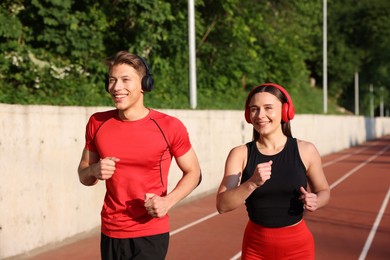 Photo of Sporty couple running at stadium. Healthy lifestyle