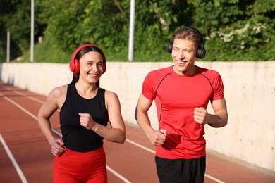 Photo of Sporty couple running at stadium. Healthy lifestyle
