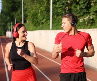 Photo of Sporty couple running at stadium. Healthy lifestyle