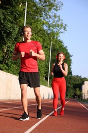 Photo of Sporty couple running at stadium. Healthy lifestyle