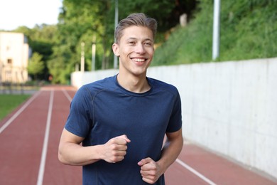Photo of Sporty man running at stadium. Healthy lifestyle