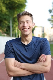 Photo of Portrait of happy sportsman at stadium. Healthy lifestyle