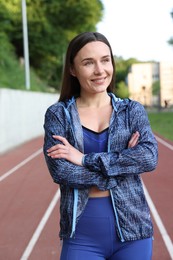 Photo of Happy woman in sportswear at stadium. Healthy lifestyle