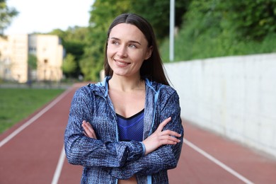 Photo of Happy woman in sportswear at stadium. Healthy lifestyle
