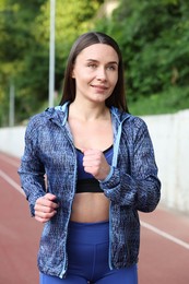Photo of Sporty woman running at stadium. Healthy lifestyle