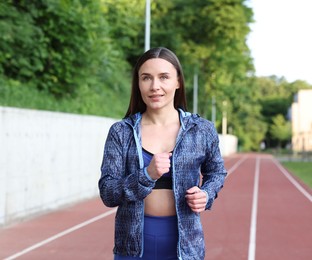 Photo of Sporty woman running at stadium. Healthy lifestyle