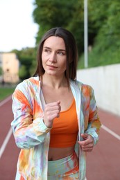 Photo of Sporty woman running at stadium. Healthy lifestyle
