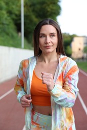 Photo of Sporty woman running at stadium. Healthy lifestyle