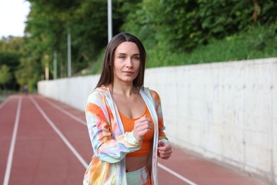 Photo of Sporty woman running at stadium. Healthy lifestyle