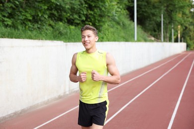 Photo of Sporty man running at stadium. Healthy lifestyle