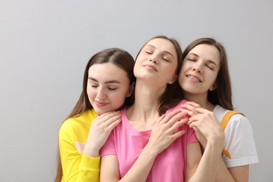 Photo of Friends hugging each other on light grey background