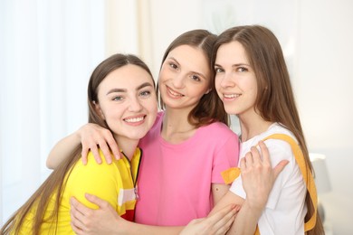 Photo of Happy friends hugging each other at home