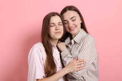 Photo of Friends hugging each other on pink background