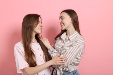 Photo of Friends hugging each other on pink background