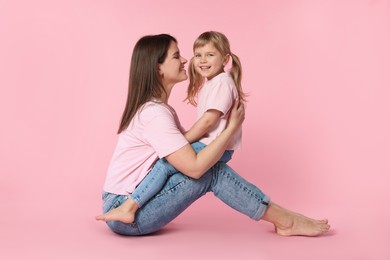 Photo of Happy mother and her cute daughter on pink background