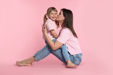 Photo of Happy mother and her cute daughter on pink background