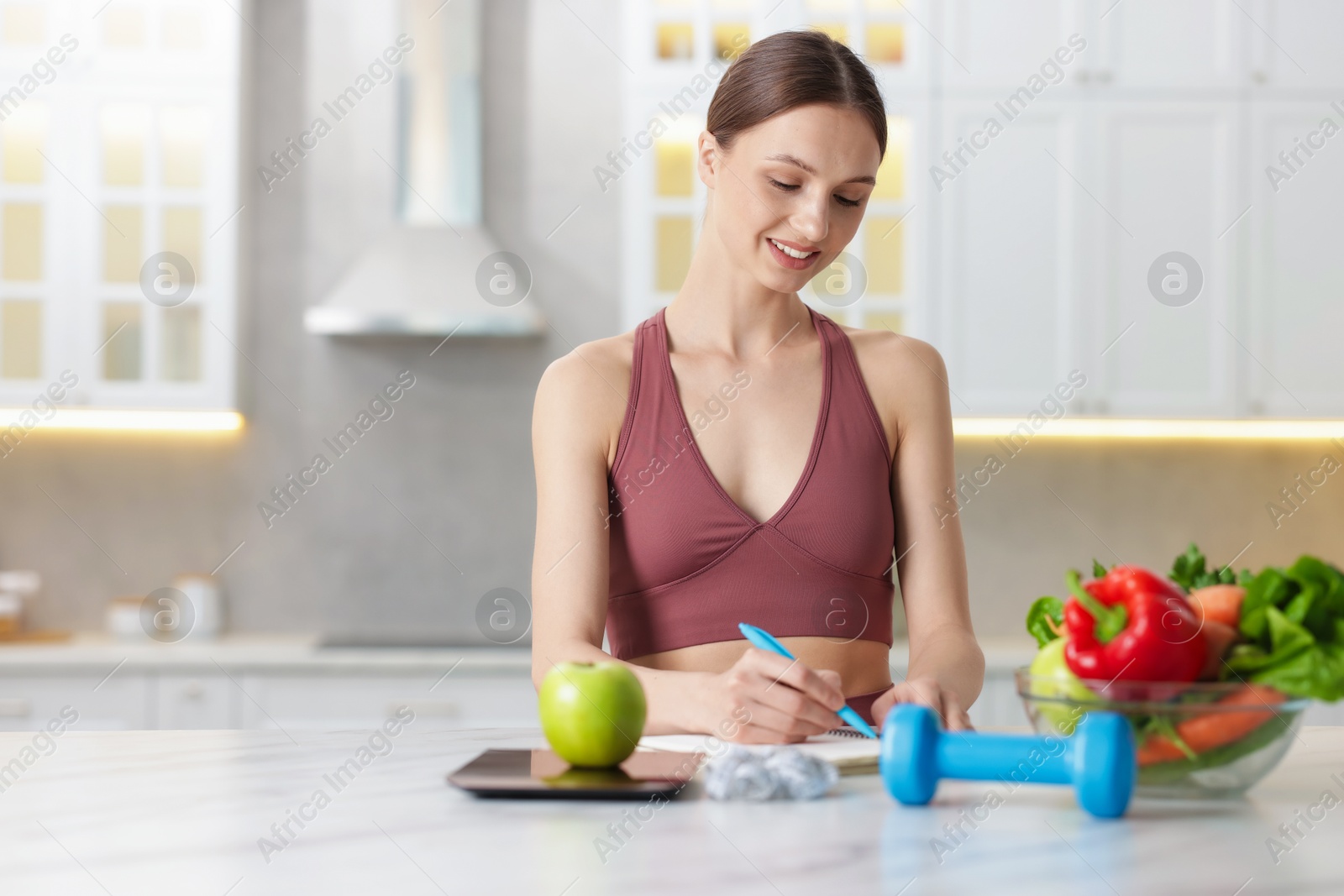 Woman developing diet plan at white marble table indoors, space for text Photo of Woman developing diet plan at white marble table indoors, space for text