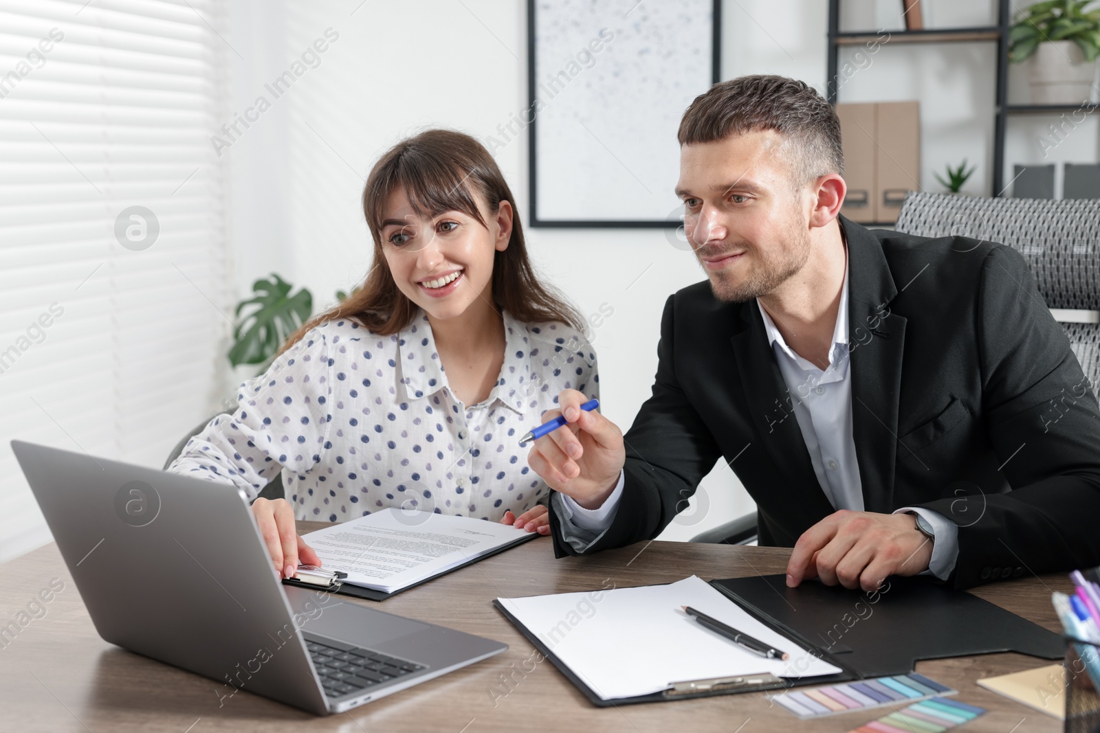 Consultant working with client at table in office. Business meeting Photo of Consultant working with client at table in office. Business meeting