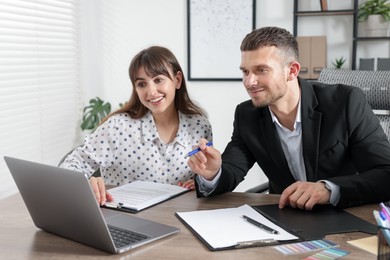 Photo of Consultant working with client at table in office. Business meeting