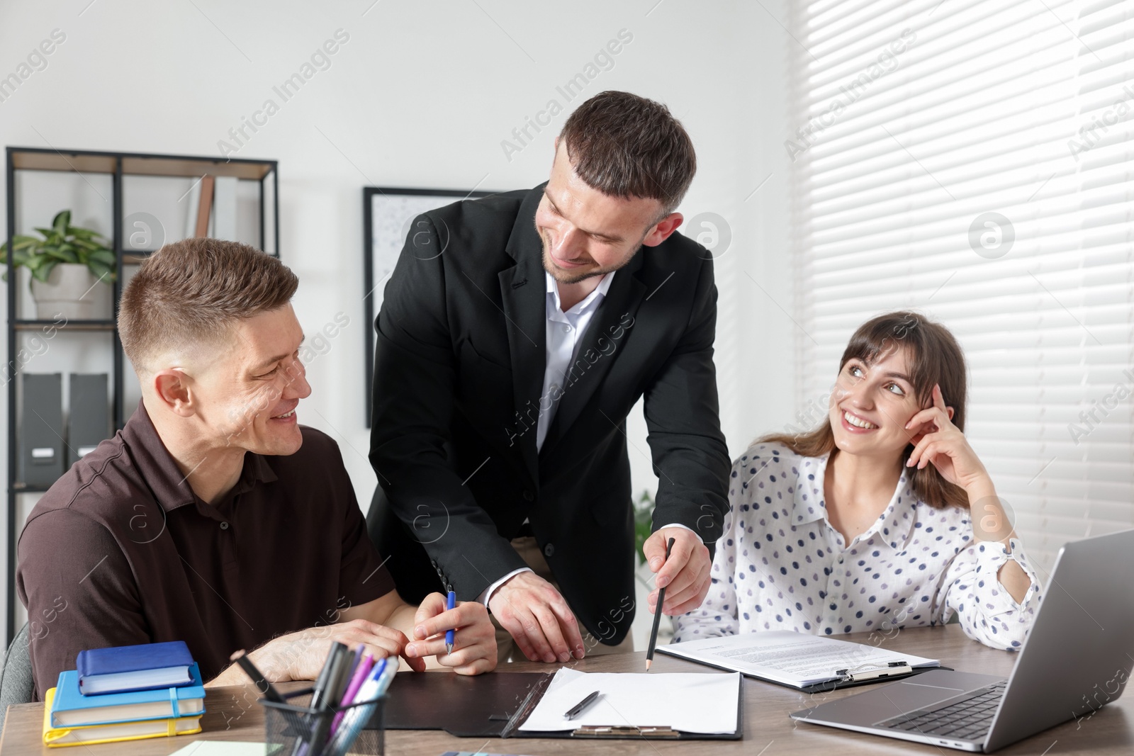 Couple having meeting with business consultant at table in office Photo of Couple having meeting with business consultant at table in office