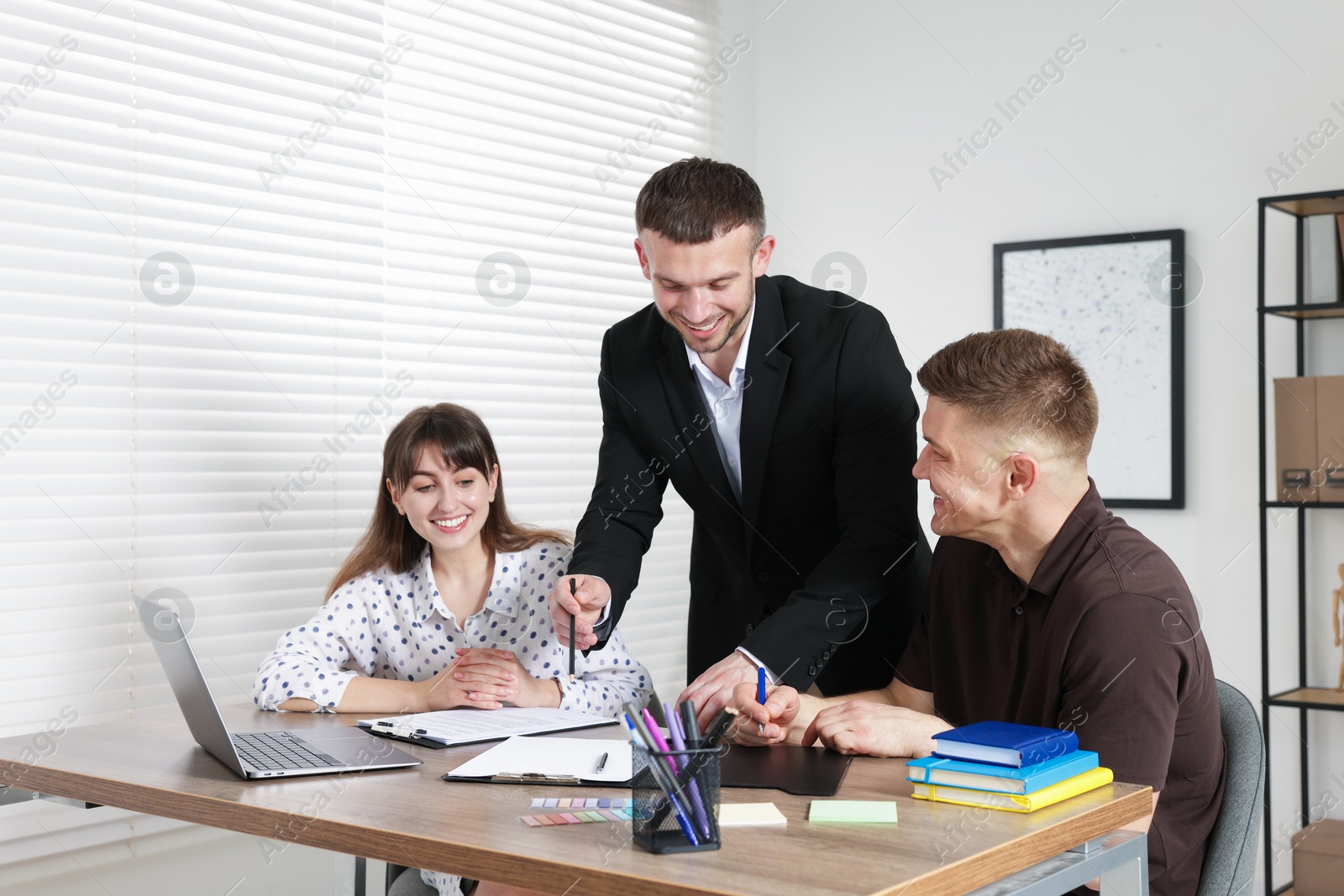 Couple having meeting with business consultant at table in office Photo of Couple having meeting with business consultant at table in office