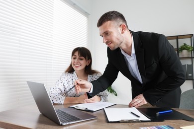 Photo of Consultant working with client at table in office. Business meeting