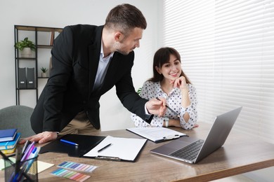 Photo of Consultant working with client at table in office. Business meeting
