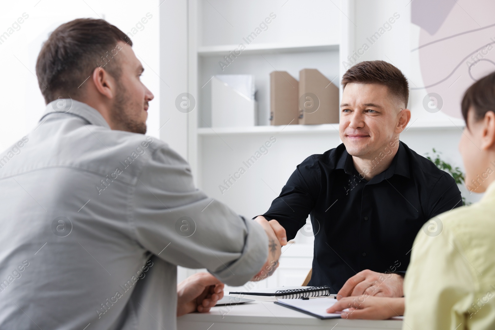 Couple having meeting with business consultant at table in office Photo of Couple having meeting with business consultant at table in office