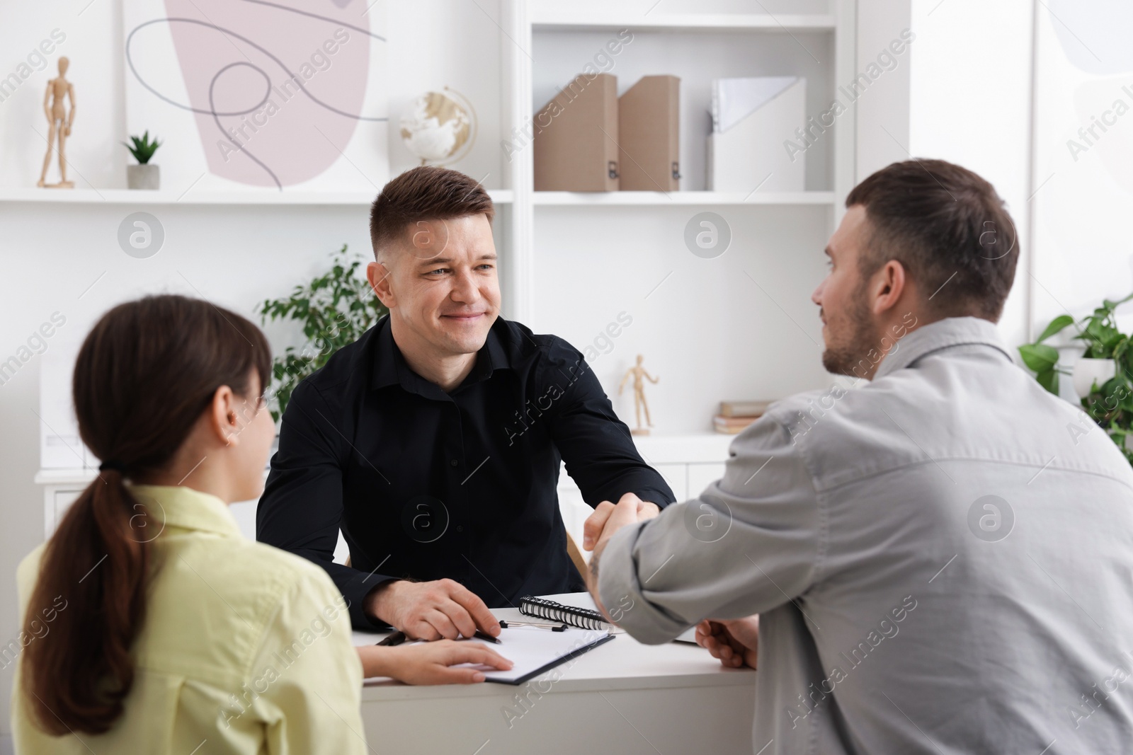 Photo of Couple having meeting with business consultant at table in office