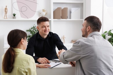 Photo of Couple having meeting with business consultant at table in office