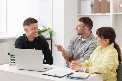 Photo of Couple having meeting with business consultant at table in office