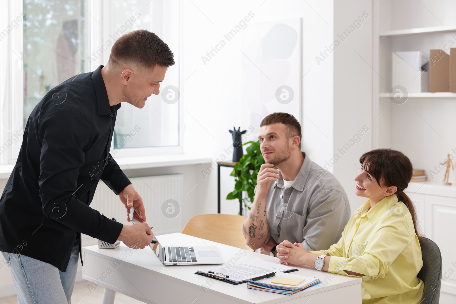 Couple having meeting with business consultant at table in office Photo of Couple having meeting with business consultant at table in office