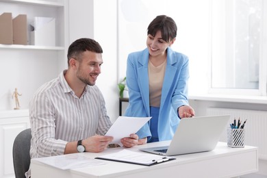 Photo of Consultant working with client at table in office. Business meeting