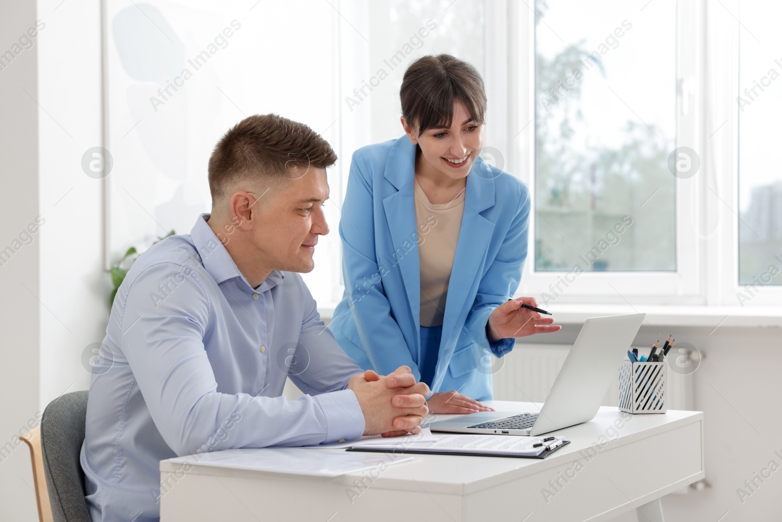 Consultant working with client at table in office. Business meeting Photo of Consultant working with client at table in office. Business meeting