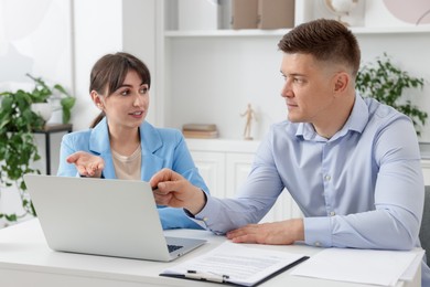 Photo of Consultant working with client at table in office. Business meeting