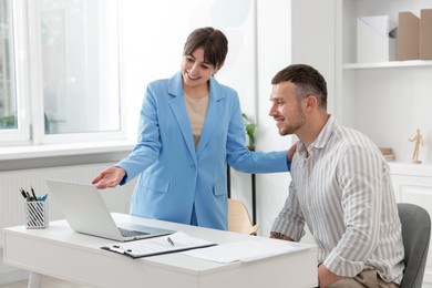 Photo of Consultant working with client at table in office. Business meeting
