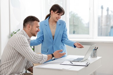 Photo of Consultant working with client at table in office. Business meeting