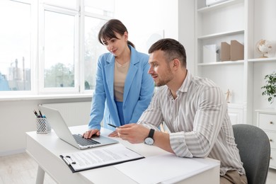Photo of Consultant working with client at table in office. Business meeting