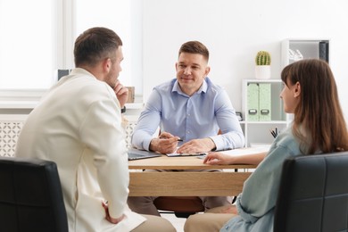 Photo of Couple having meeting with business consultant at table in office
