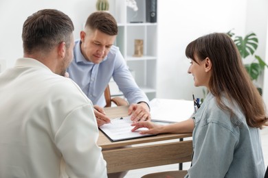 Photo of Couple having meeting with business consultant at table in office, selective focus