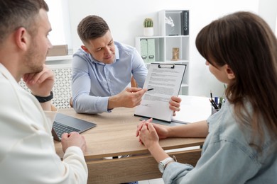 Photo of Couple having meeting with business consultant at table in office