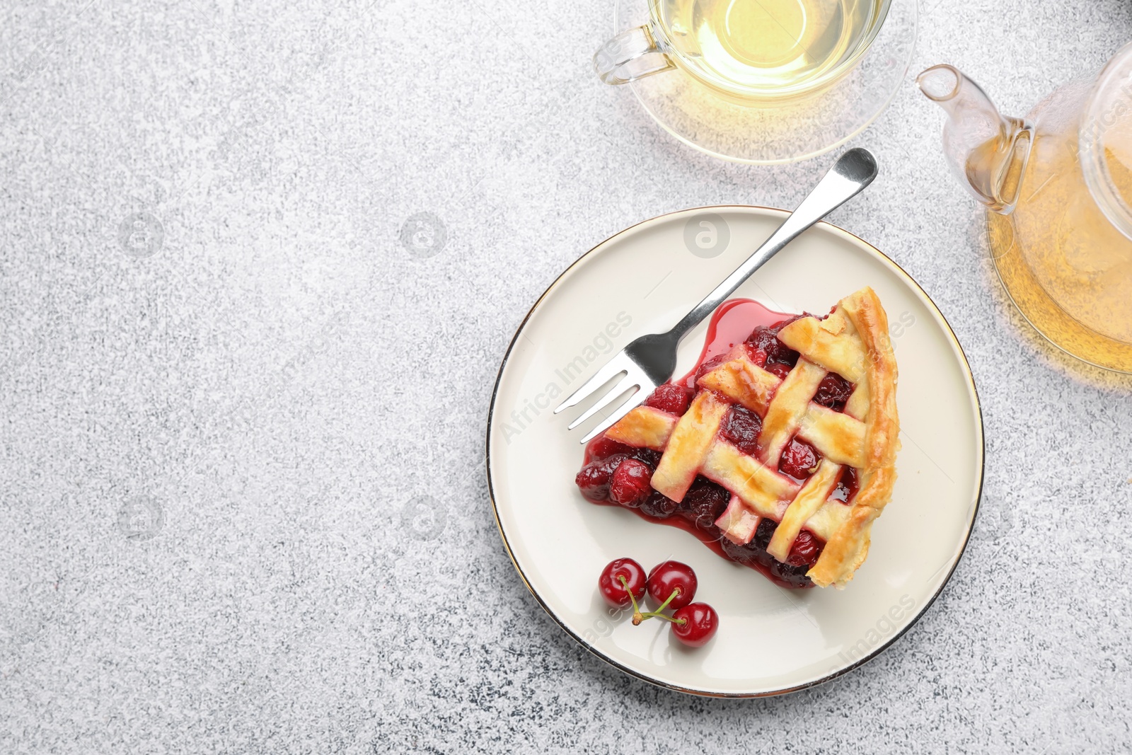 Piece of tasty cherry pie, berries and tea on grey textured table, flat lay. Space for text Photo of Piece of tasty cherry pie, berries and tea on grey textured table, flat lay. Space for text
