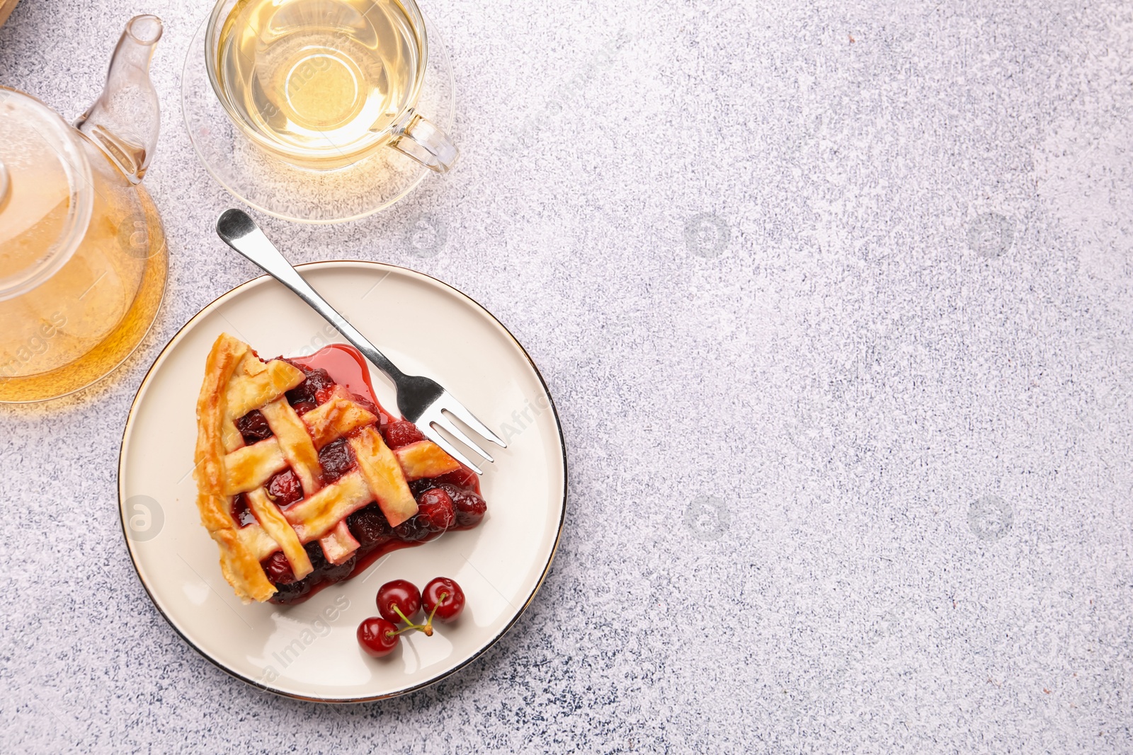 Piece of tasty cherry pie, berries and tea on grey textured table, flat lay. Space for text Photo of Piece of tasty cherry pie, berries and tea on grey textured table, flat lay. Space for text