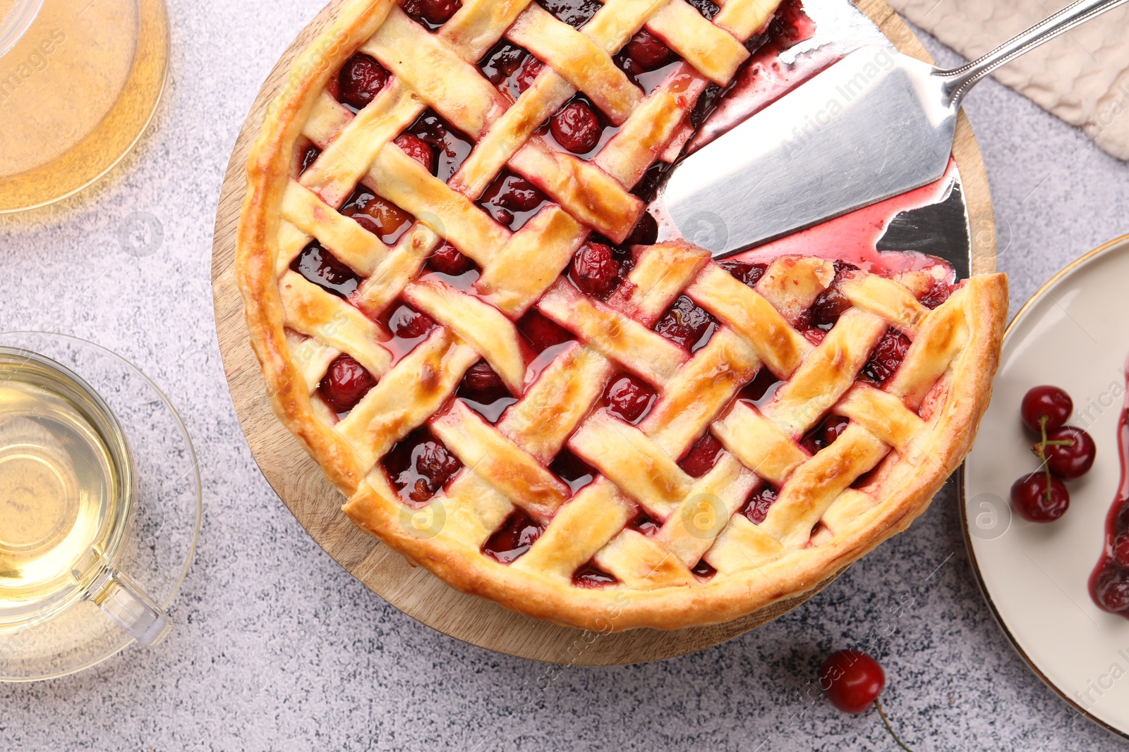 Tasty cherry pie, berries and tea on grey textured table, flat lay Photo of Tasty cherry pie, berries and tea on grey textured table, flat lay