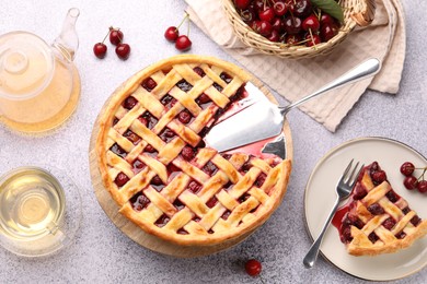 Photo of Tasty cherry pie, berries and tea on grey textured table, flat lay