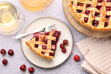 Photo of Tasty cherry pie, berries and tea on grey textured table, flat lay