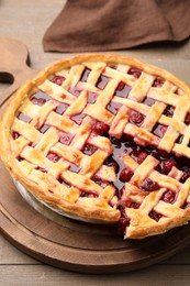 Photo of Tasty cut cherry pie on wooden table, closeup