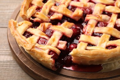 Photo of Tasty cut cherry pie on wooden table, closeup