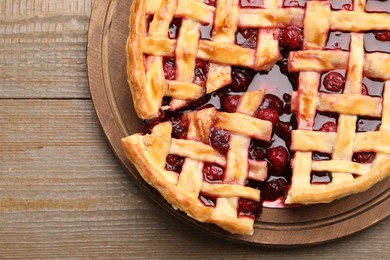 Photo of Tasty cut cherry pie on wooden table, top view