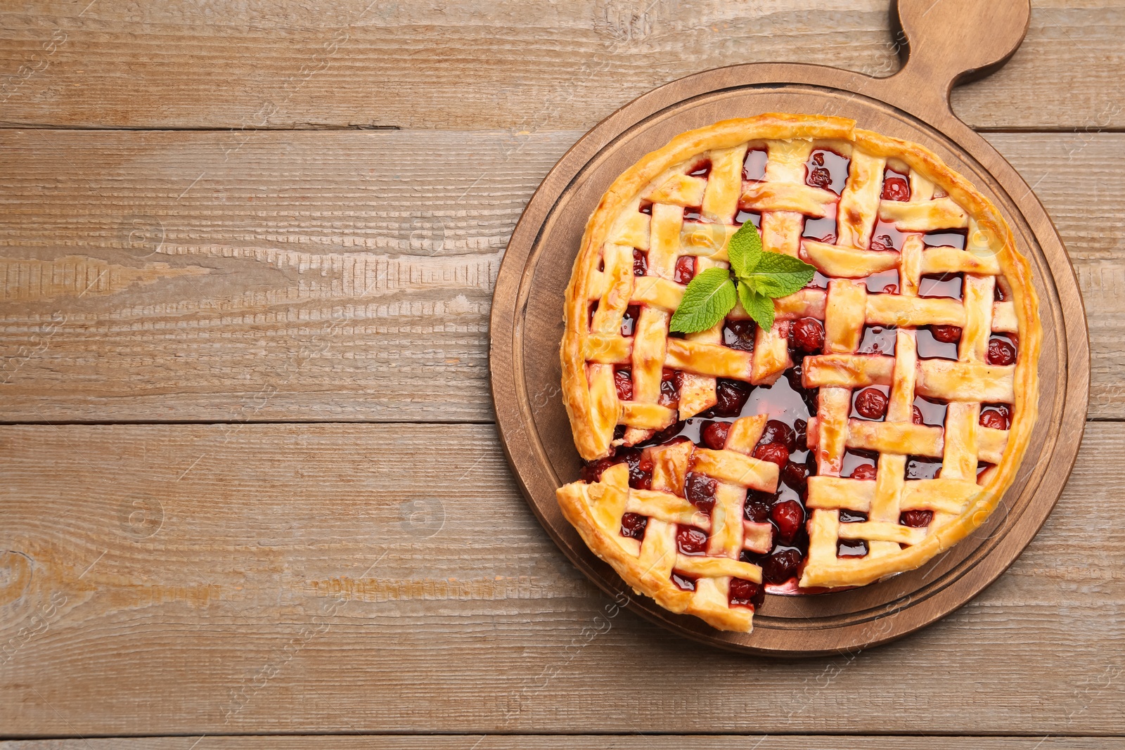Tasty cut cherry pie on wooden table, top view. Space for text Photo of Tasty cut cherry pie on wooden table, top view. Space for text